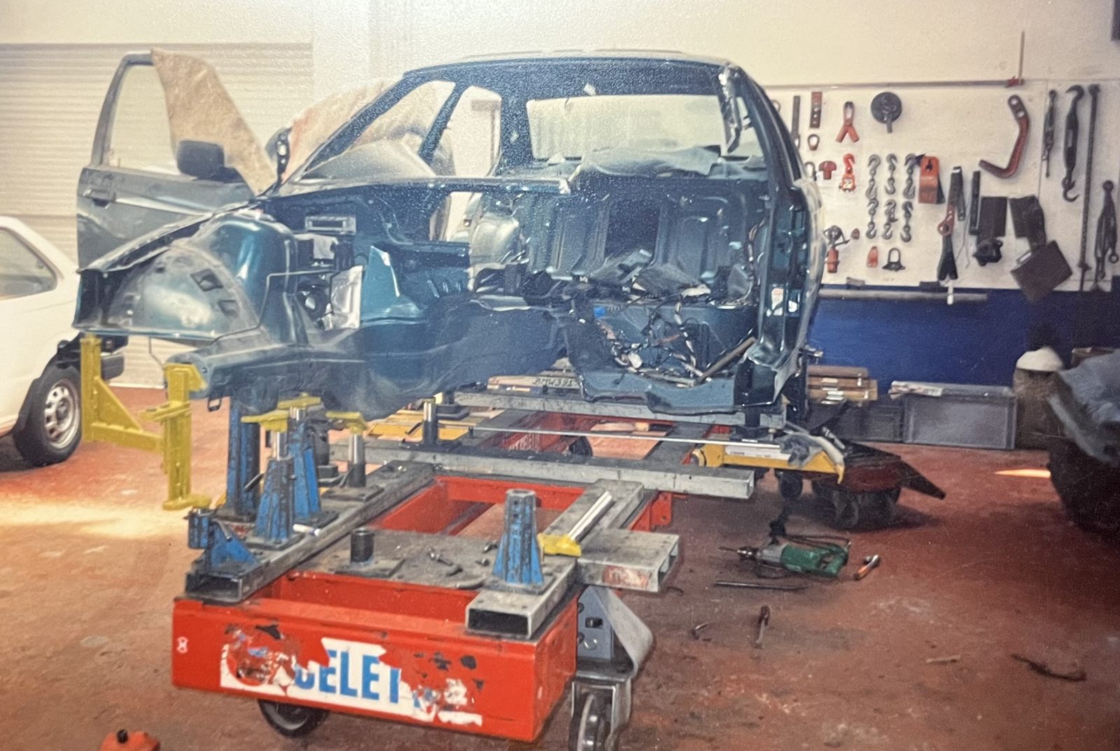 Een carrosserie opgespannen op de richtbank in de werkplaats van Carrosserie Dieltjens